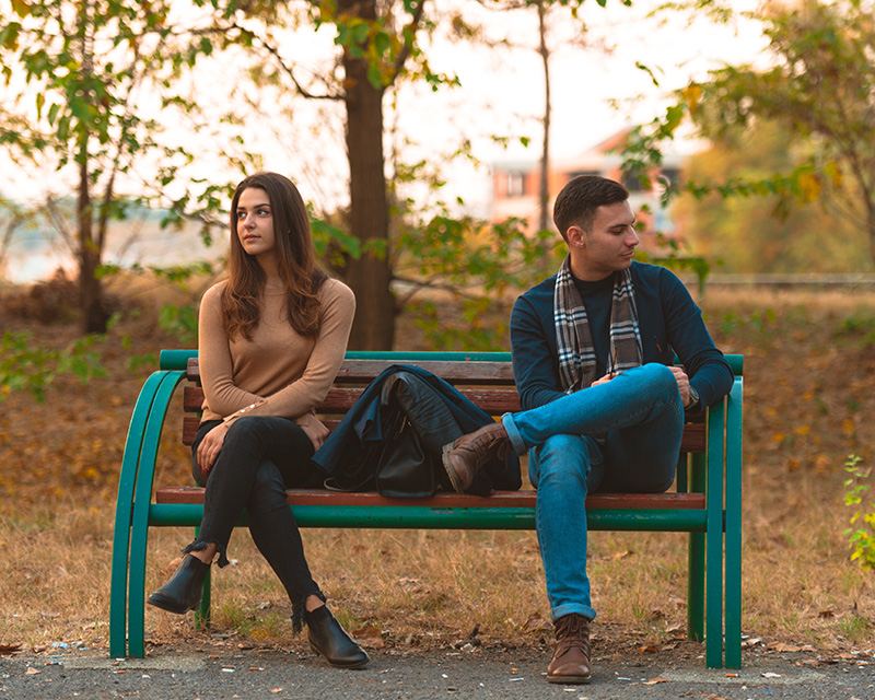 Couple looking in opposite directions trying to find a path forward in their relationship with discernment counseling.